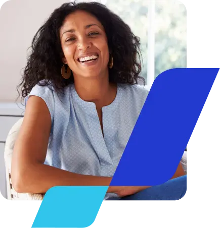 No canto esquerdo, há a imagem de uma mulher negra, sorrindo. Ela tem cabelos compridos, usa brincos de argola e veste uma camisa social azul, sem mangas. Está sentada, com o cotovelo apoiado no braço da cadeira. Como composição, temos a haste do banco BV emoldurando a foto, em primeiro plano.