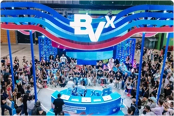 Foto de estande do BVx nas cores azul, com pessoas assistindo a um painel, branco e magenta no Web Summit 2024