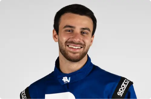 O piloto Felipe Baptista sorri e veste um macacão azul com o logo do banco BV.