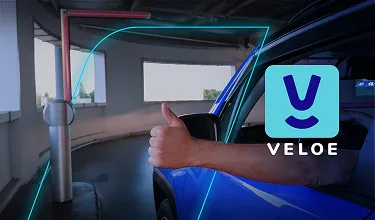 Uma pessoa dentro de um carro, que usa a Tag Veloe do banco BV, dando joia para um sistema de cobrança no estacionamento.