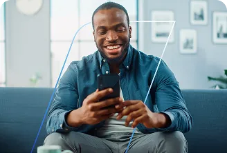 Homem sorridente sentado no sofá segurando o celular