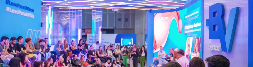 Grupo de pessoas em evento sobre tecnologia com painel sobre o banco BV