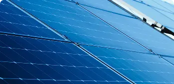 Close em painéis solares azuis alinhados, superfície fotovoltaica refletindo luz.