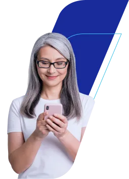 Fotografia de mulher de cabelo grisalho e óculos, com fundo de grafismo azul. Sorri enquanto mexe em celular rosa.