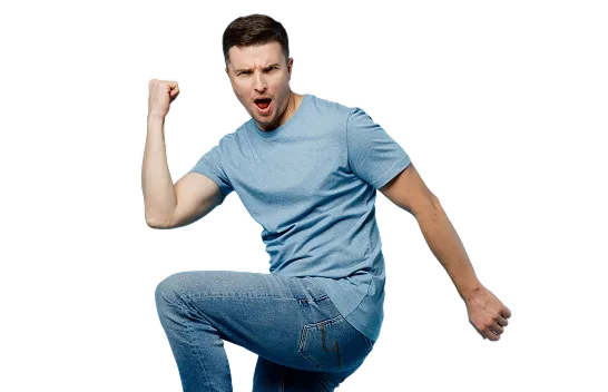 Fotografia de homem de camiseta azul e jeans com fundo preto. Ele está com boca aberta, braço erguido e joelho levantado.