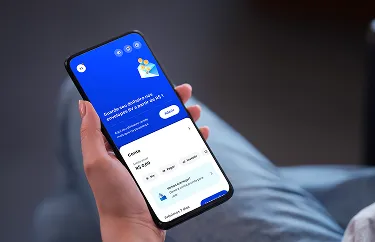 Uma mão segurando um celular aberto no aplicativo do banco BV, na tela de “Envelopes”.
