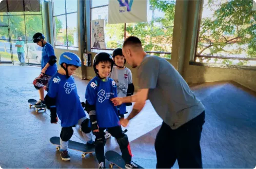 Sandro Dias, ex-atleta profissional de skate vertical, com crianças andando de skate no Instituto Sandro Dias.
