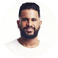 Surfista Ítalo Ferreira, de camiseta branca, sorrindo.