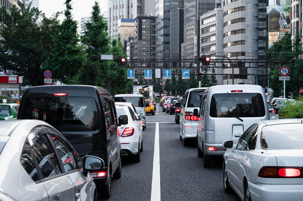 Trânsito intenso em avenida urbana com carros parados no semáforo, ilustrando o fim do DPVAT e a possibilidade de alternativas de proteção como o seguro de acidentes pessoais BV.
